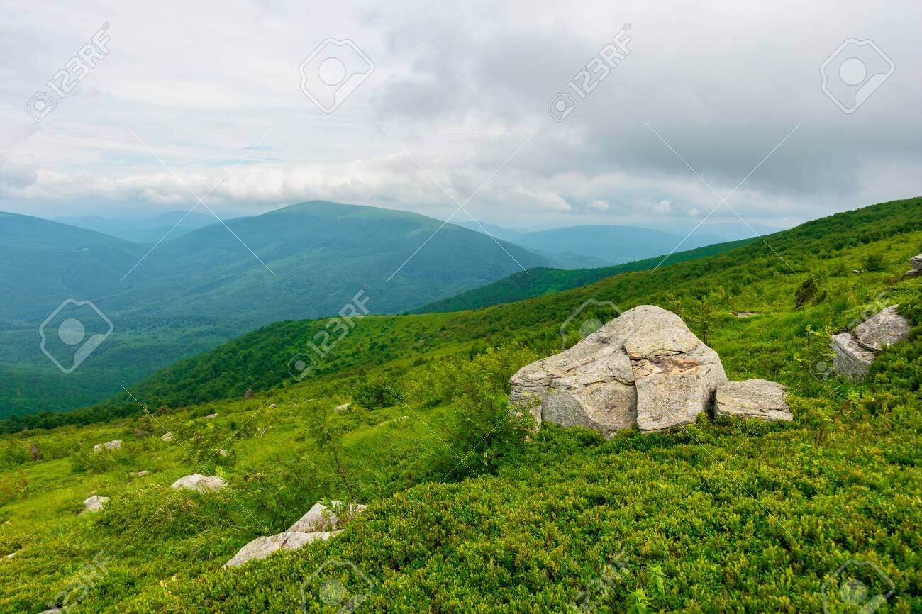 boulders on the alpine hillside. view from the edge of a hill. beautiful summer landscape in mountains. overcast windy weather with grey clouds on the sky - 151738563 boulders on the alpine hillside. view from the edge of a hill. beautiful summer landscape in mountains. overcast windy weather with grey clouds on the sky - 151738563