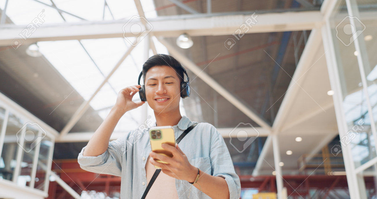 https://previews.123rf.com/images/peopleimages12/peopleimages122302/peopleimages12230203325/198167781-phone-music-headphones-and-asian-man-walking-in-mall-streaming-podcast-or-radio-technology-travel.jpg