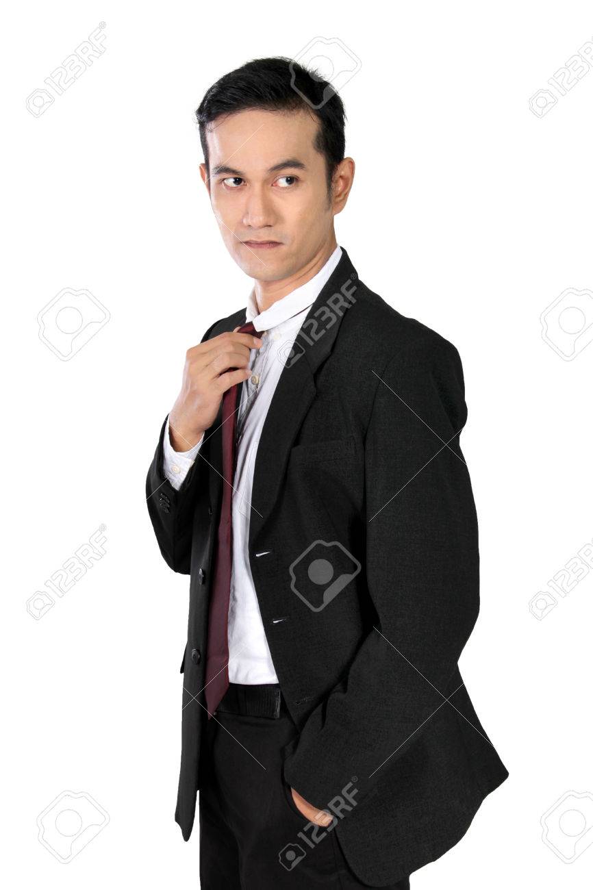 フォーマル スーツ内ポケット 1 つの手と 1 つの手の彼のネクタイ 白い背景で隔離の調整で自信を持ってアジア系のビジネスマンのクールなポーズ の写真素材 画像素材 Image