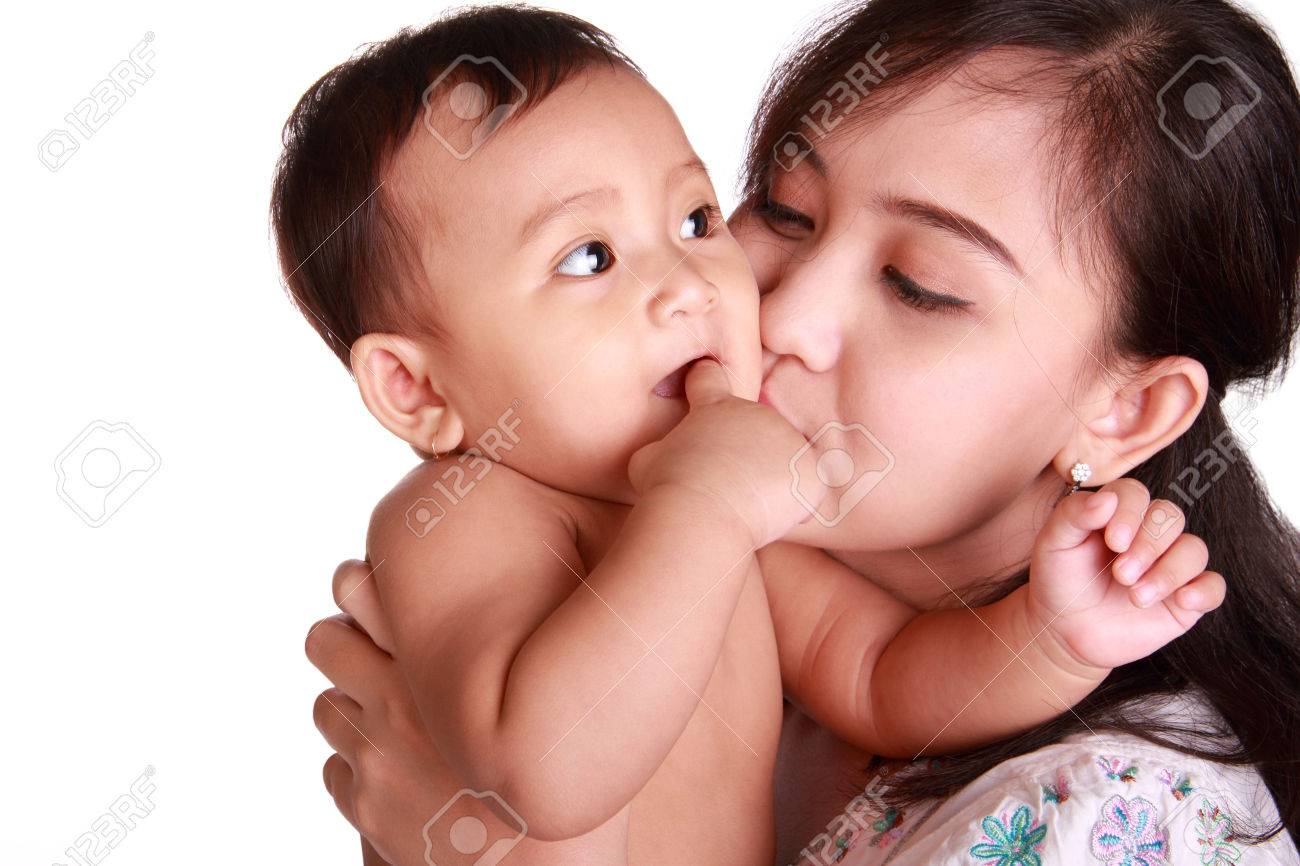 かわいい赤ちゃん彼女の指を噛んで 白い背景に分離した 彼女のお母さんにキスをしました の写真素材 画像素材 Image