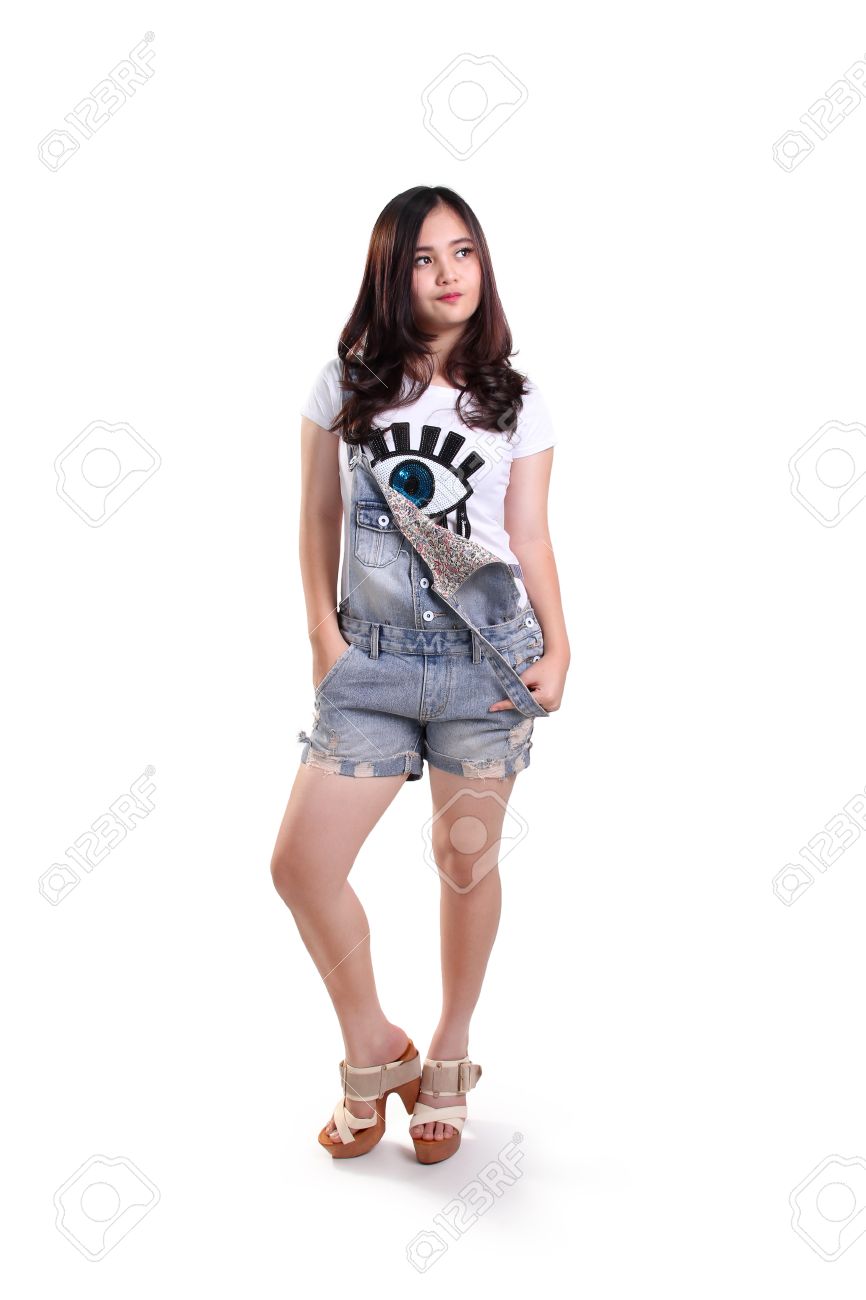 Full body pose of cool asian teenage girl standing over white studio background stock photo