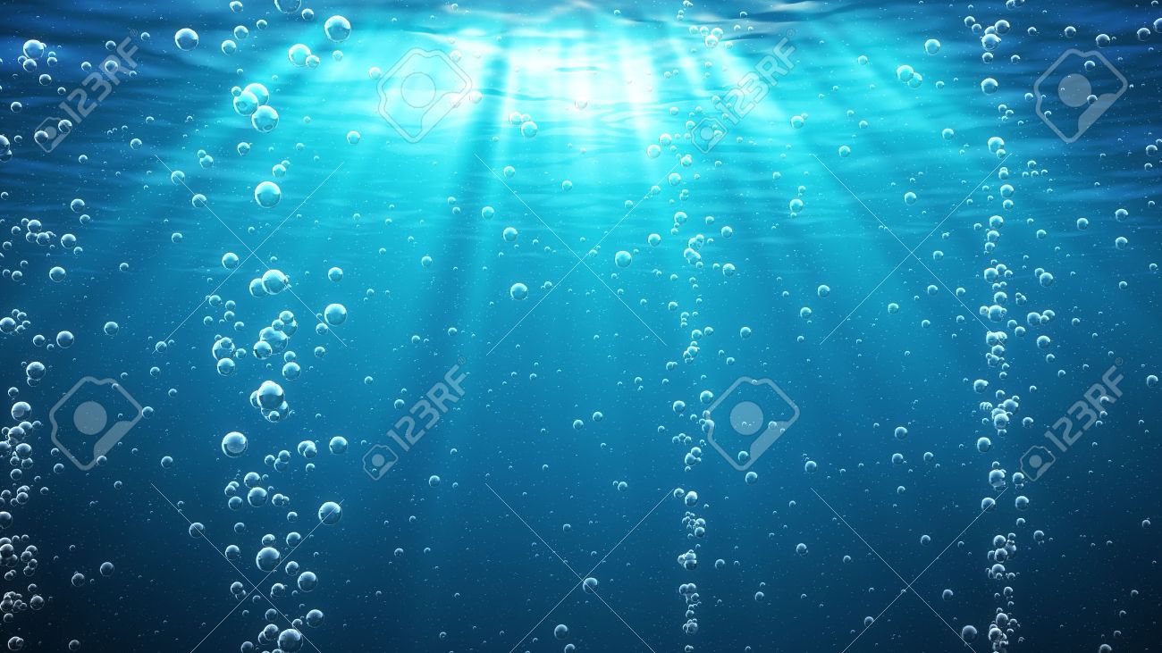 Blue Ocean Waves From Underwater With Bubbles Light Rays Shining