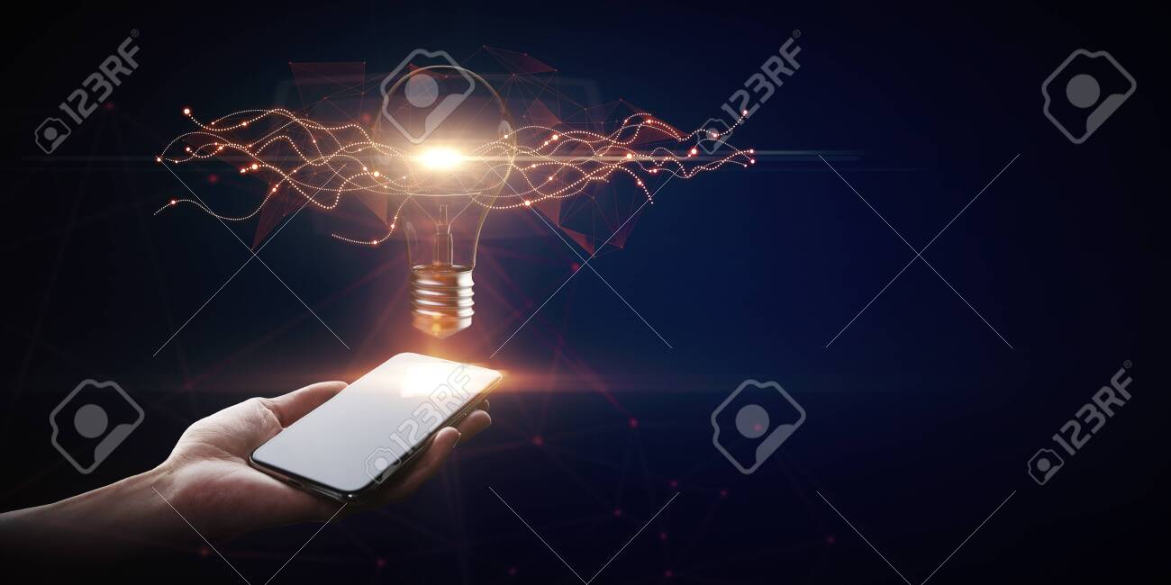 Hand holding smartphone with creative glowing lamp on dark background. Idea and innovation concept - 123559641 Hand holding smartphone with creative glowing lamp on dark background. Idea and innovation concept - 123559641