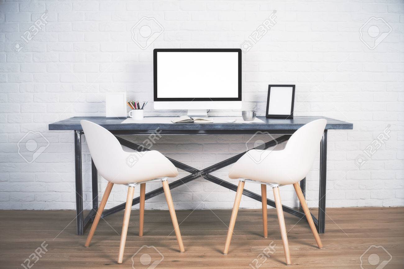 Two Chairs Next To Designer Desk With Blank White Computer Screen