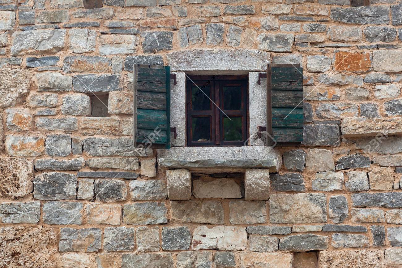 レンガに閉じたシャッターが付く古い木製窓の石垣します の写真素材 画像素材 Image