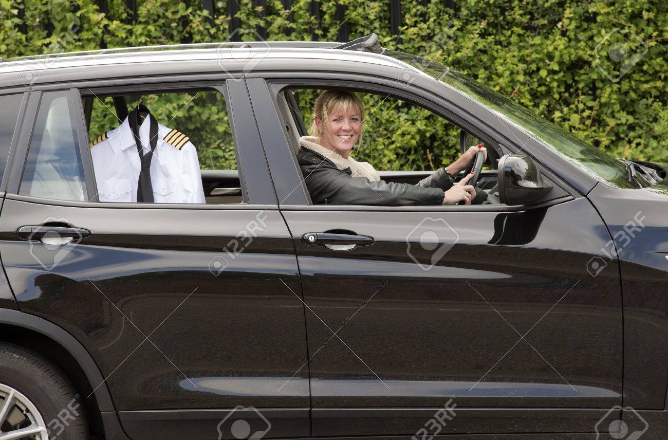 女性が車の窓にハンガーで彼女の制服を操作する運転 の写真素材 画像素材 Image