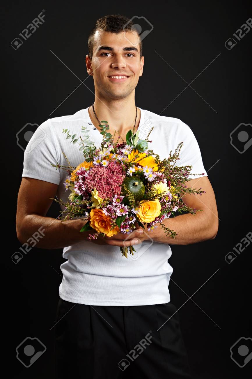 Young Smiling Man In White Shirt Holds Bouquet Of Flowers On Dark Background Stock Photo Picture And Royalty Free Image Image 3227