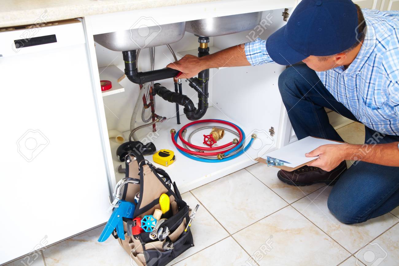 Plumber with Plumbing tools on the kitchen. Renovation. - 45779475 Plumber with Plumbing tools on the kitchen. Renovation. - 45779475
