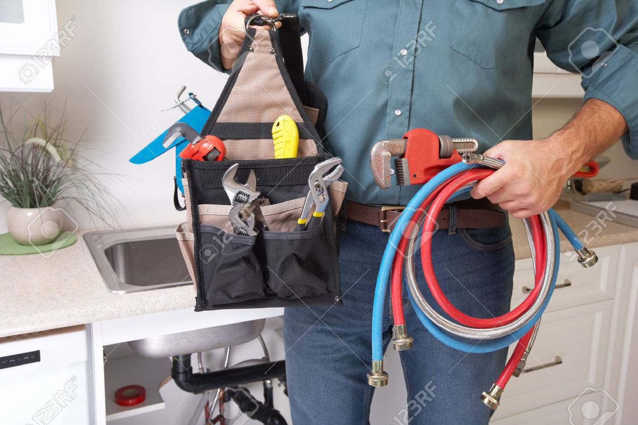 Plumber with Plumbing tools on the kitchen. Renovation. - 50576771 Plumber with Plumbing tools on the kitchen. Renovation. - 50576771