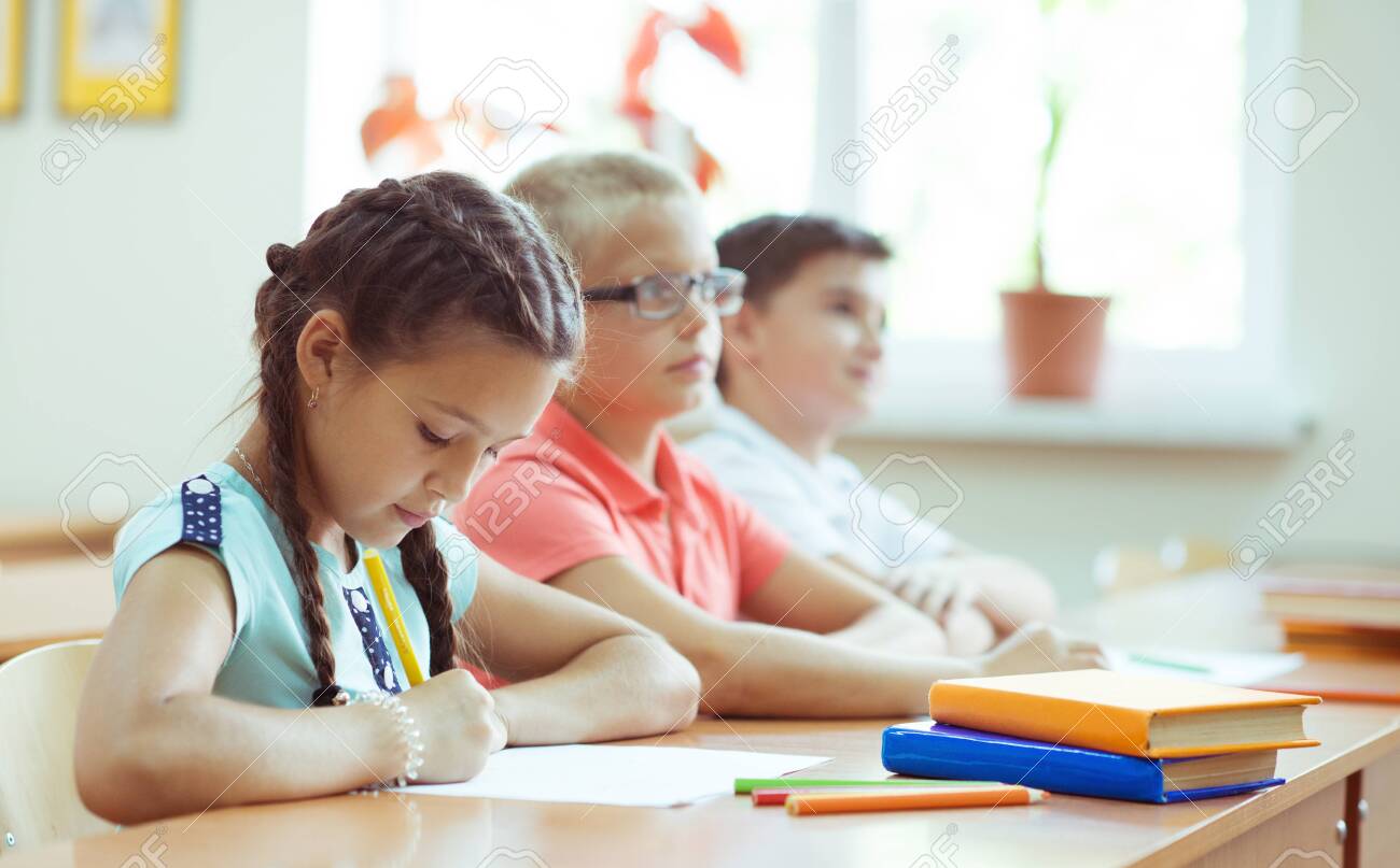 Happy schoolchildren studing and answer questions in classroom during a lesson at primary school - 137803585 Happy schoolchildren studing and answer questions in classroom during a lesson at primary school - 137803585