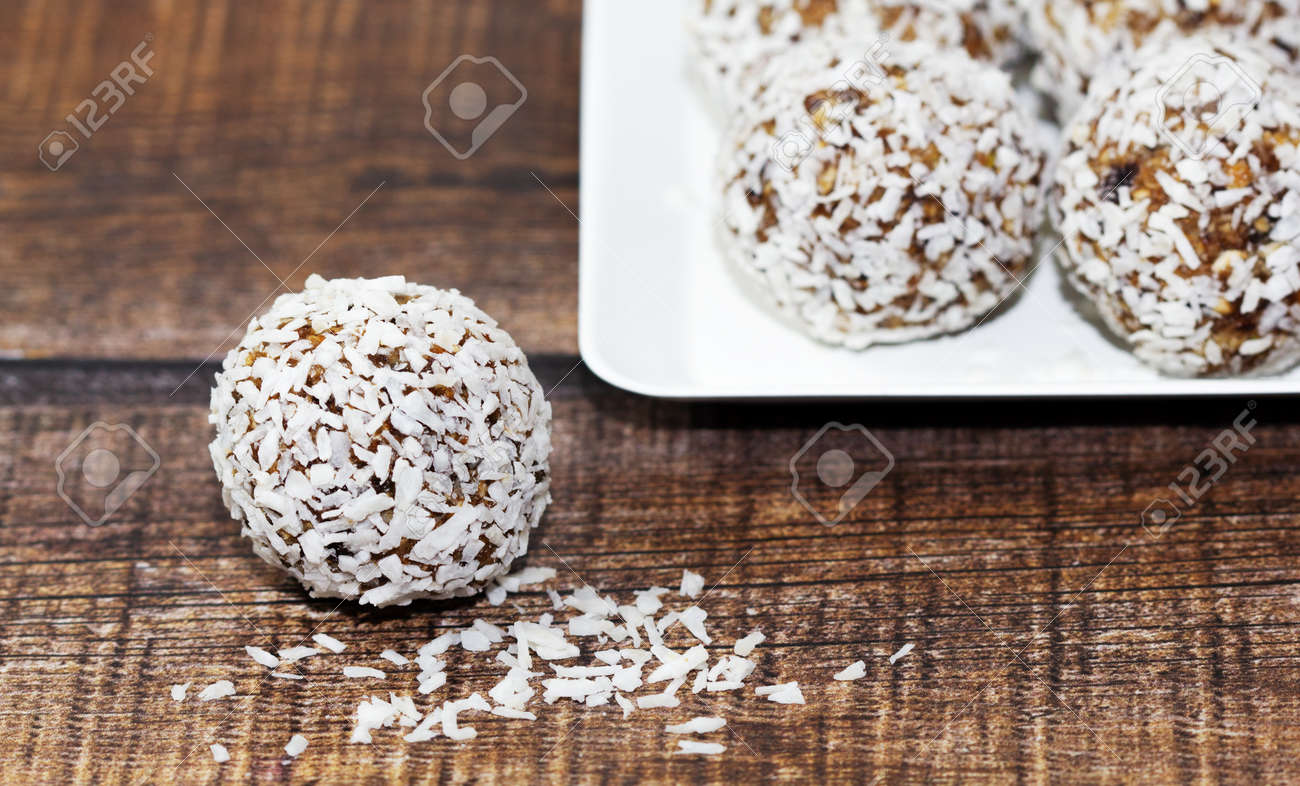 Homemade energy balls with dried apricots, raisins, dates, prunes, walnuts and coconut. Healthy sweet food. Energy balls in a plate on a wooden background. Close up. Side view. Copy space - 170430108 Homemade energy balls with dried apricots, raisins, dates, prunes, walnuts and coconut. Healthy sweet food. Energy balls in a plate on a wooden background. Close up. Side view. Copy space - 170430108