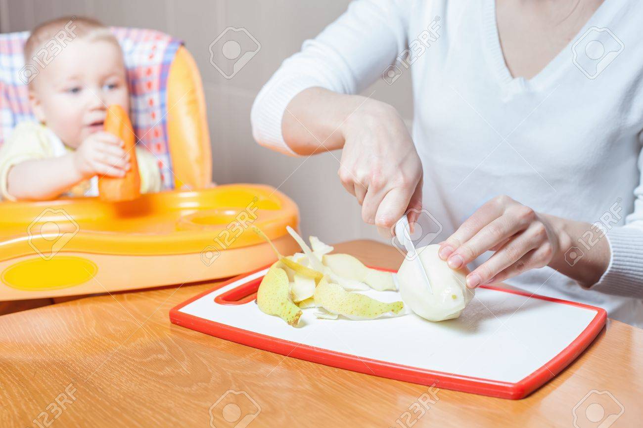 離乳食の準備 調理の母 赤ちゃんのための食品 レシピ 赤ちゃん のケア 健康栄養 食事 子テーブルでハイチェアに座っています キッチン ホーム 新鮮なフルーツ 洋ナシ テーブルの上のリンゴ の写真素材 画像素材 Image