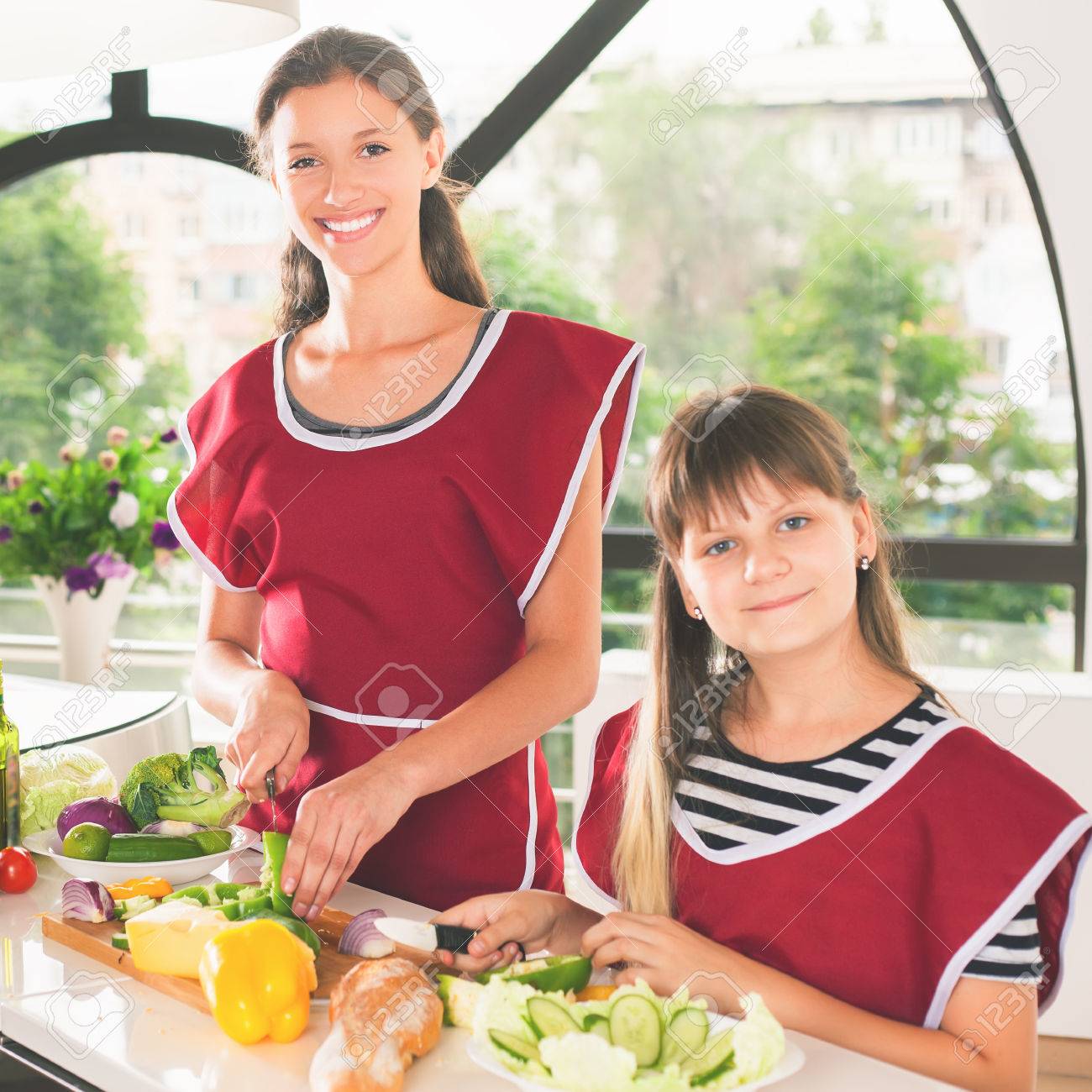 若い女の子の料理の幸せな家族 キッチンで菜食主義の食事 面白い姉妹がサラダを作るします 健康的なライフ スタイル ビタミン栄養のレシピ カメラ目線の 女の子 の写真素材 画像素材 Image