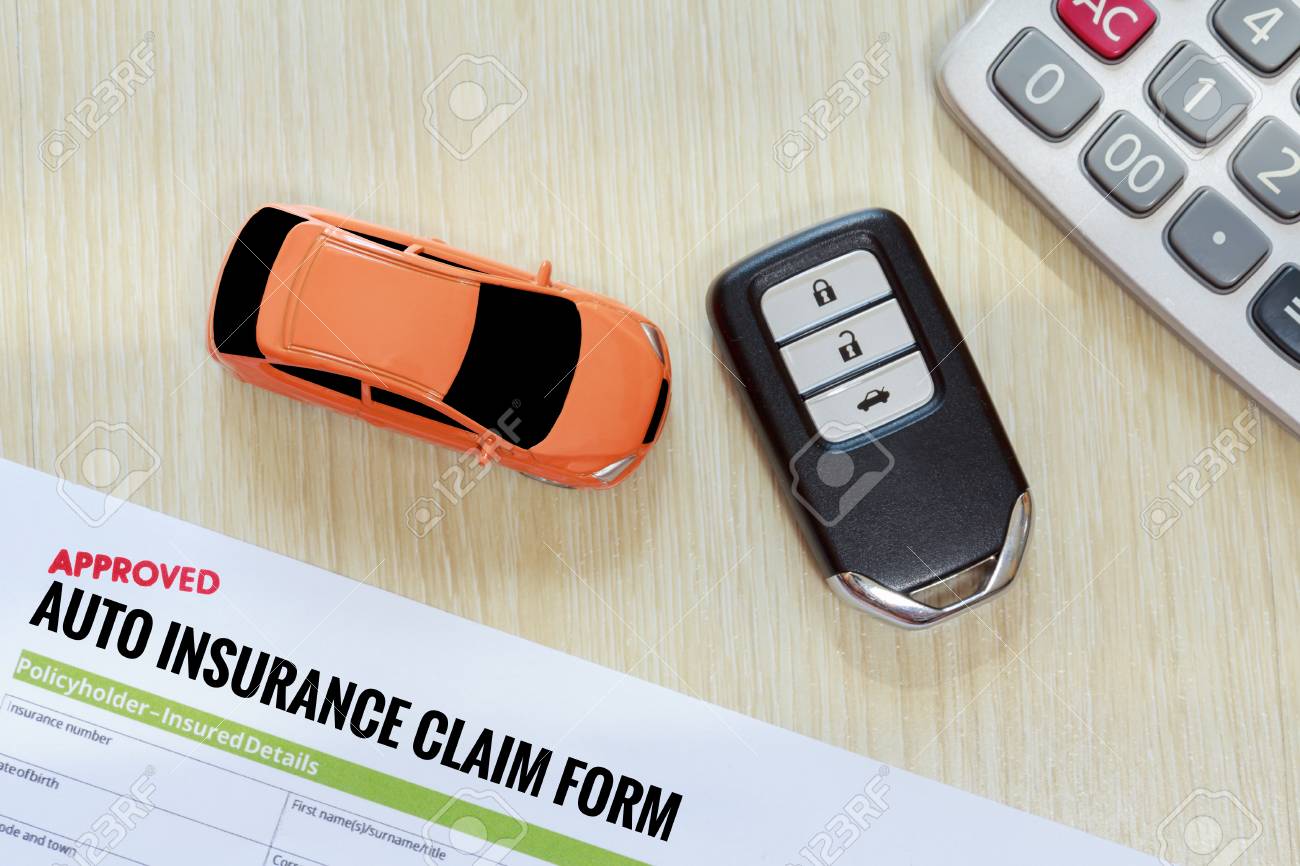 承認された自動車保険の請求書と車の鍵 車のおもちゃ 木製の机の上の電卓 の写真素材 画像素材 Image