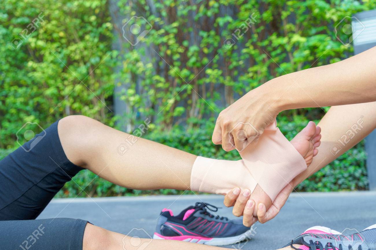 適用されている若い女性ランナー足首包帯公園で男に 傷害足首 の写真素材 画像素材 Image