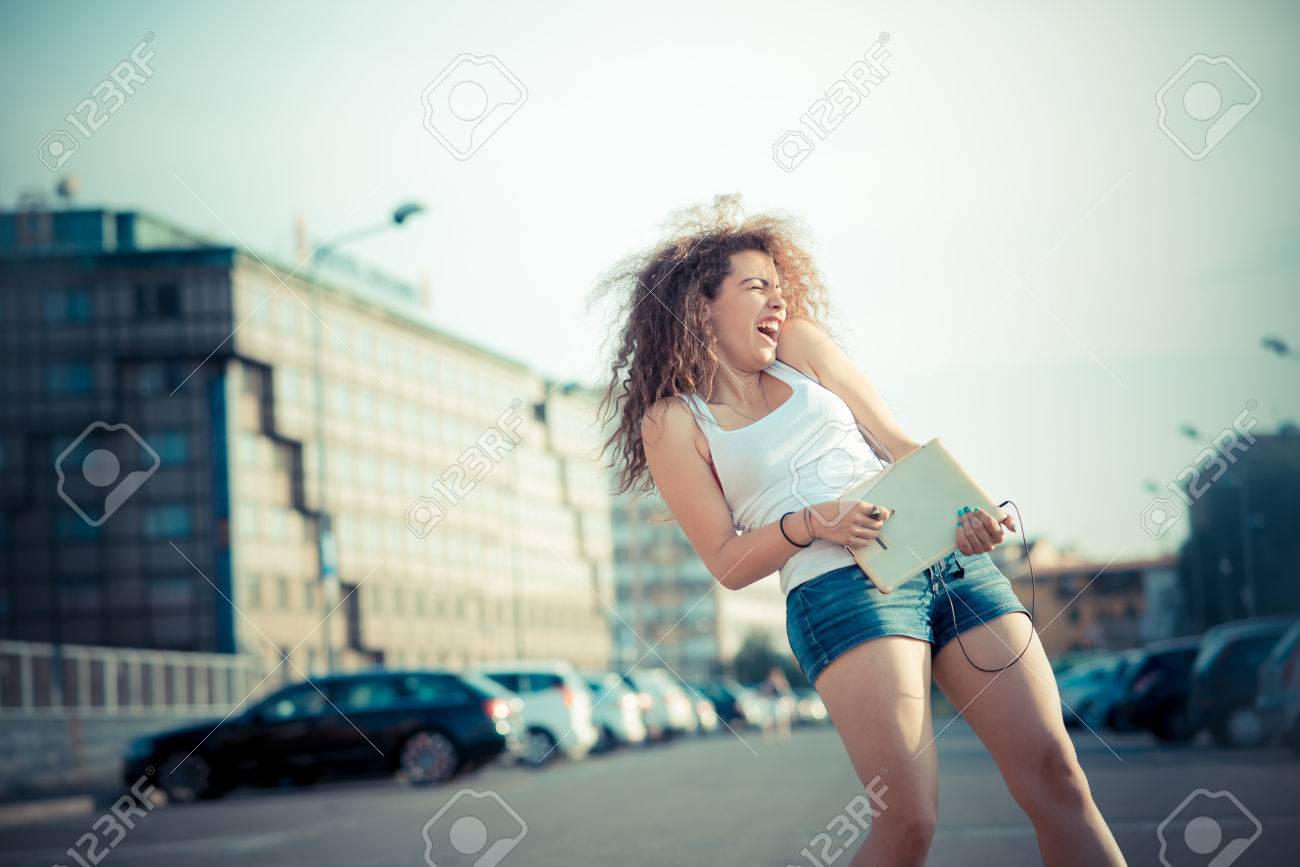 https de 123rf com photo 31784028 junge sch c3 b6ne lange lockige haare hipster frau die musik mit tablette in der stadt html