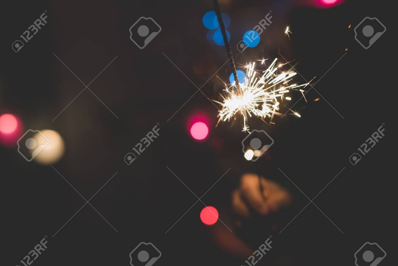 線香花火の開催を祝う若いハンサムな白人短い茶色の髪の女性の半分の長さの肖像画 の写真素材 画像素材 Image