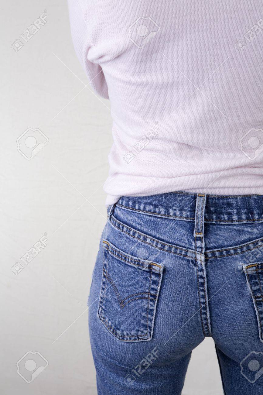 Rear Shot Of A Woman In Blue Jeans And Pink Shirt. Left Side Of Female Body