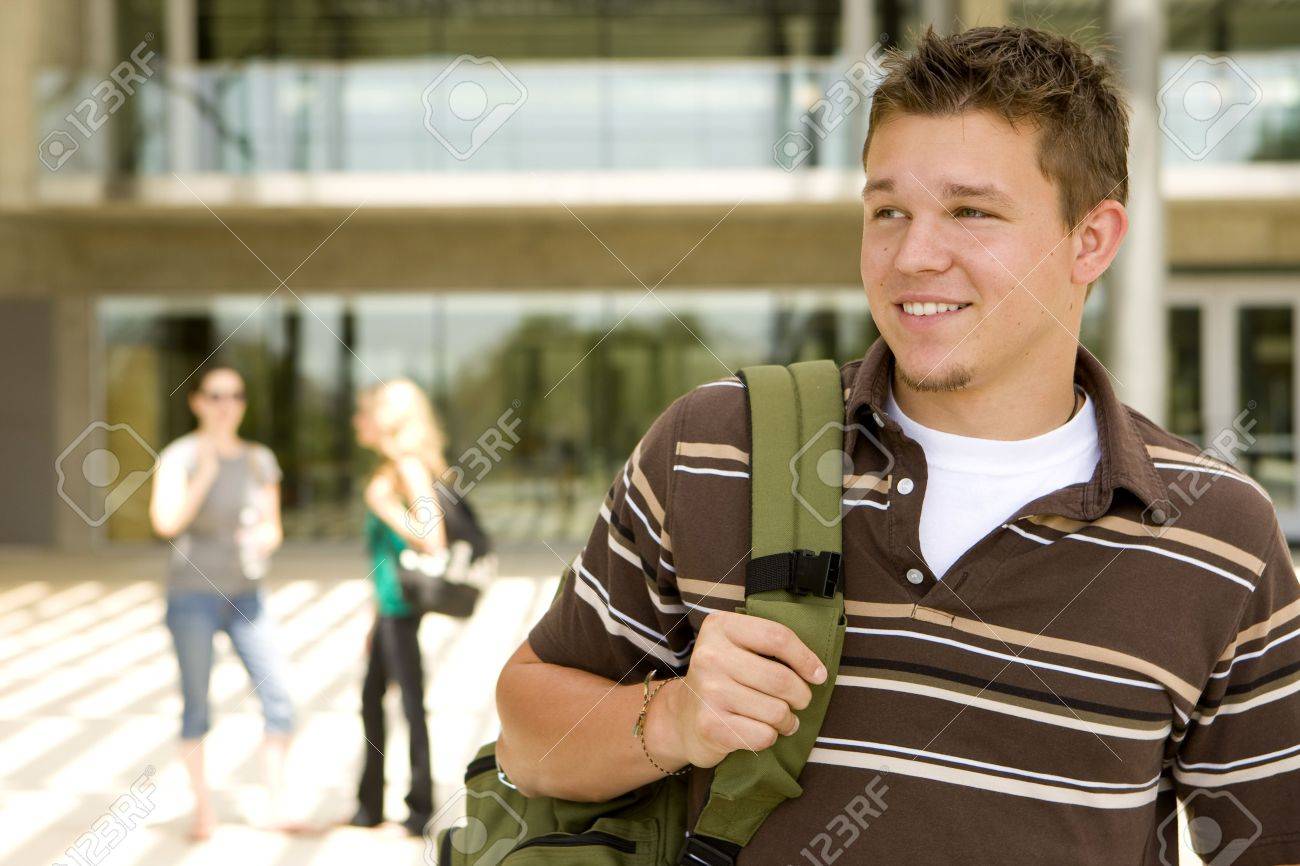 Young man at school holding a book bag - 5583390 Young man at school holding a book bag - 5583390