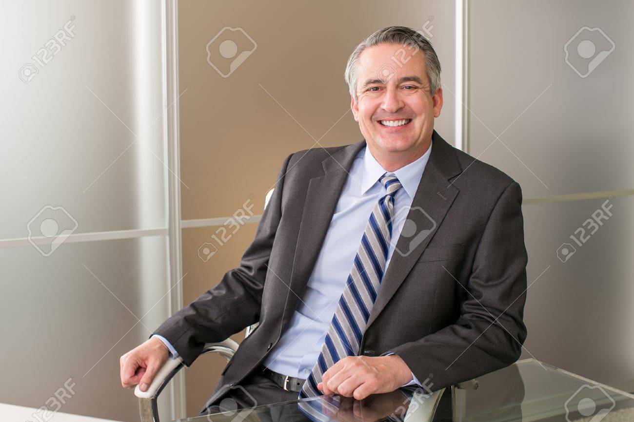 Mature happy smiling business man in an office - 46943334 Mature happy smiling business man in an office - 46943334