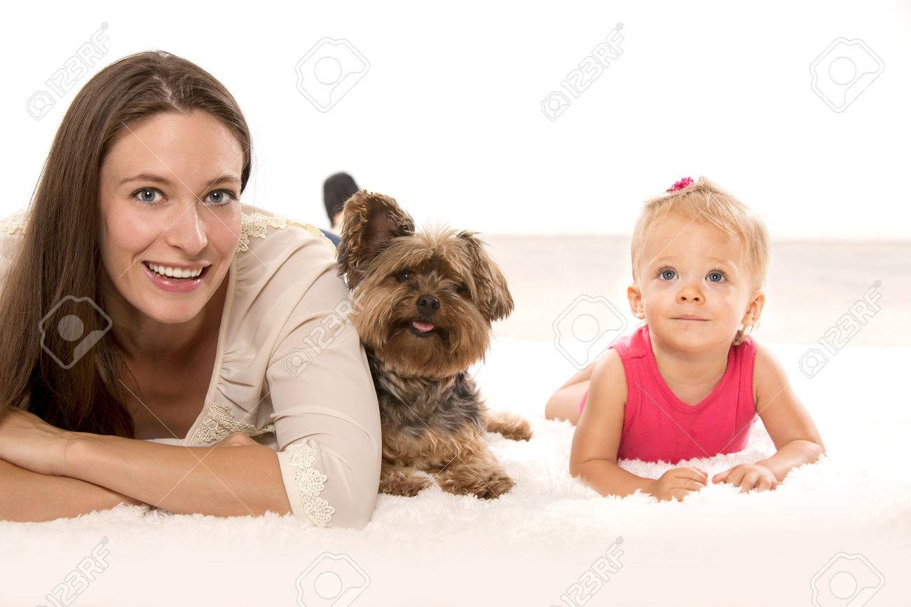 Mother with her daughter and their dog lying down - 46943430 Mother with her daughter and their dog lying down - 46943430