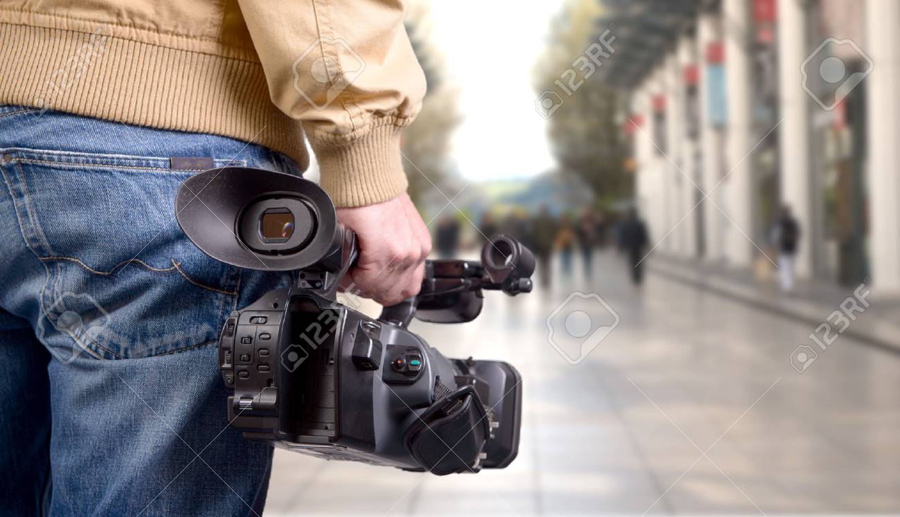 cameraman holding his professional camcorder in the street - 74960068 cameraman holding his professional camcorder in the street - 74960068