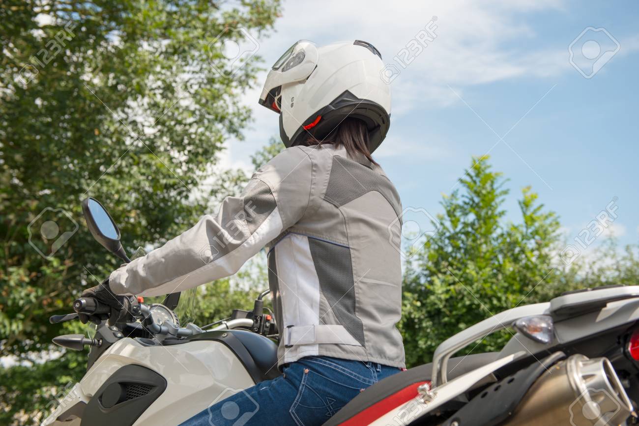 かわいい女の子のバイクに座っているし 彼の頭にヘルメットを持って の写真素材 画像素材 Image