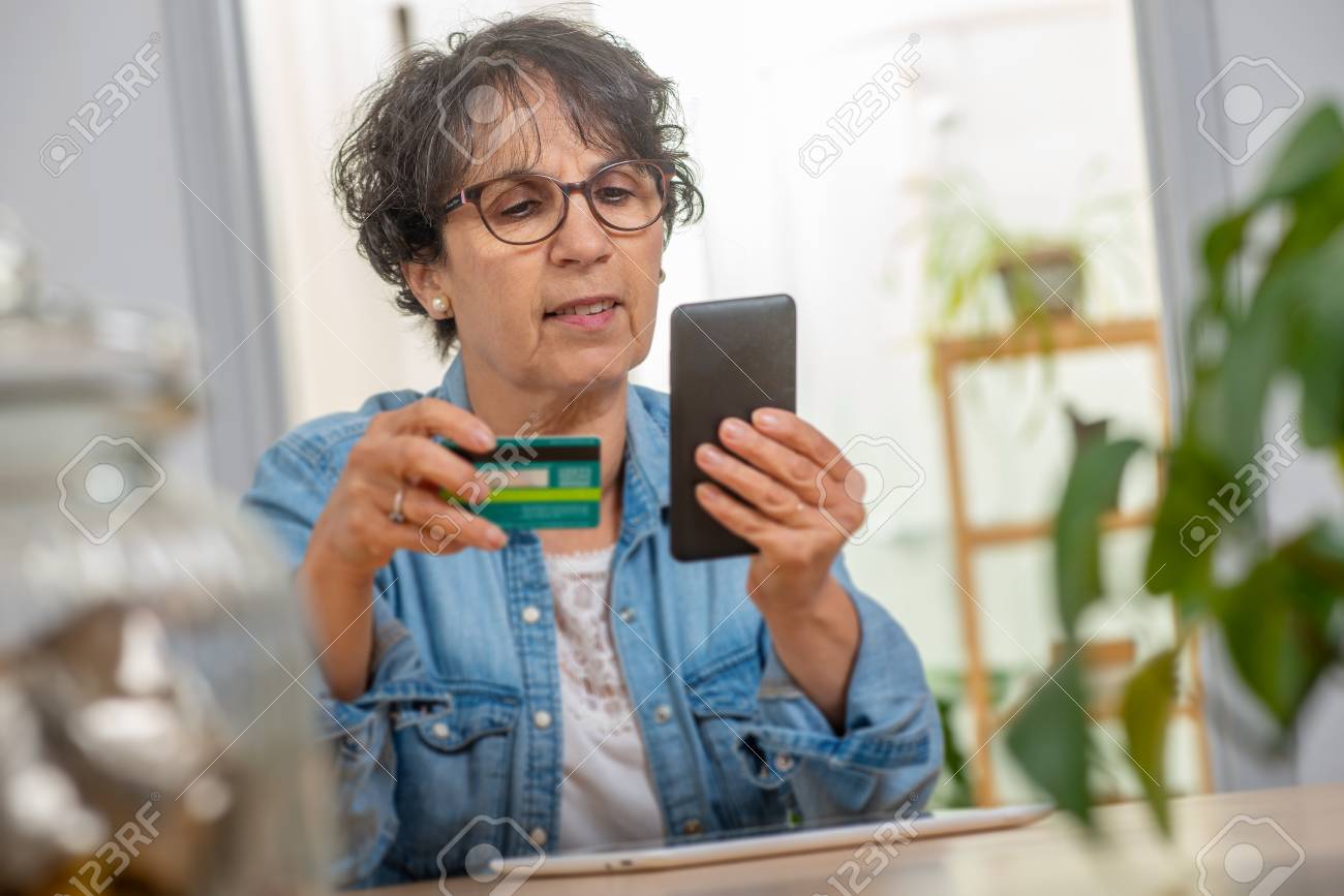 a senior brunette woman shopping with internet - 116319735 a senior brunette woman shopping with internet - 116319735