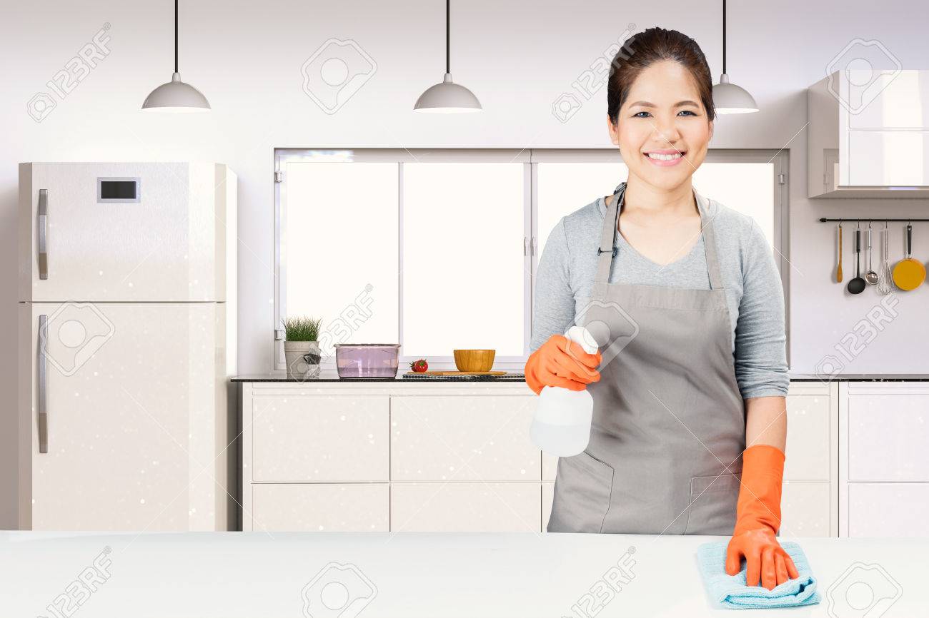 Asian Housekeeper Cleaning On Table