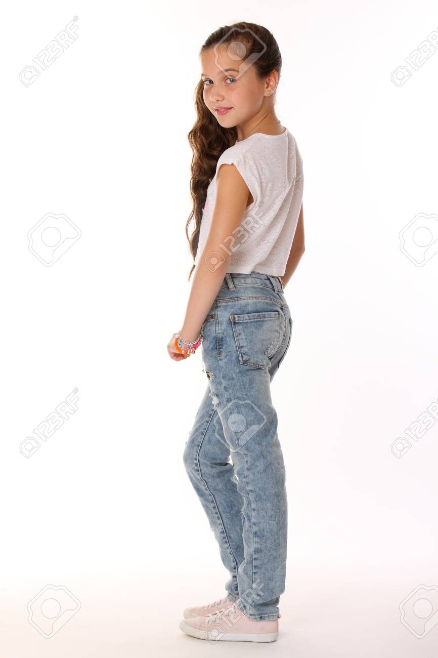Junges Jugendlich Madchen Des Recht Schonen Brunette In Der Blue Jeans Der Entzuckende Schlanke Jugendliche Der Auf Einem Weissen Hintergrund In Den Sportschuhen Steht Das Bild Der Sommermode Der Kinder Lizenzfreie Fotos