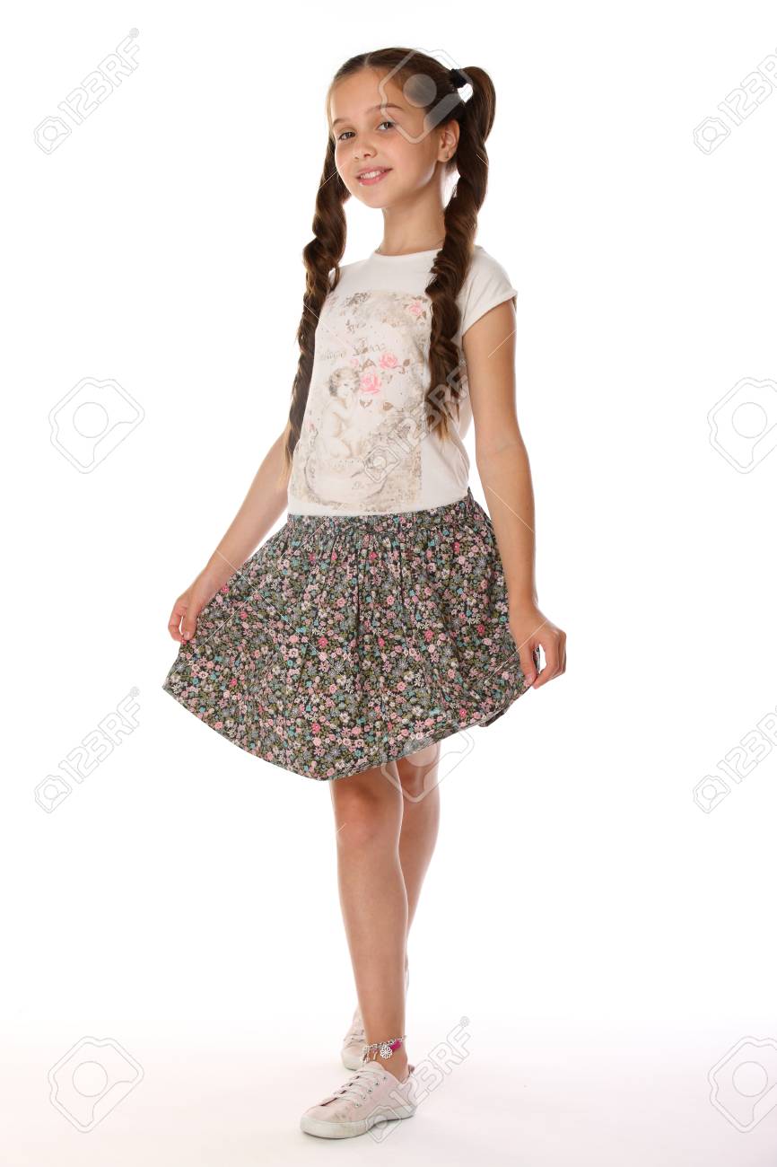 夏服を着てポーズをとる12歳の少女 魅力的なかなり細い若いティーンエイジャーは素足のスカートです 美しいブルネットの子供は 完全な長さで立っているとわずかに笑顔 の写真素材 画像素材 Image