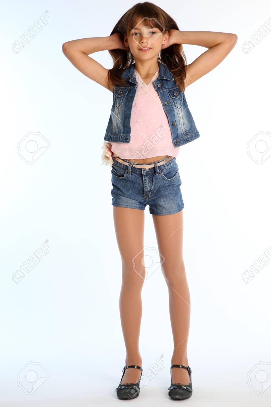 ショーパン JC デニムショートパンツの美少女が全長で立っている。パンストで細いボディと長い脚を持つエレガントな魅力的な子供。その若い女子高生は9歳です。の写真素材・画像素材 Image 100516702