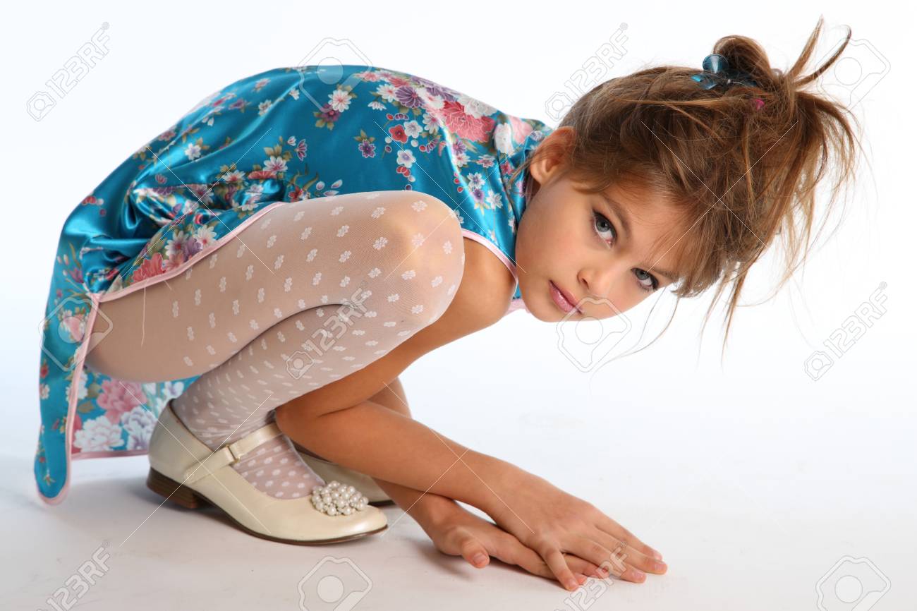 little girls in pantihose Beautiful Girl In An Asian Blue Dress Is Sitting On A White Background. Elegant Attractive Child With A Slender Body And Long Legs In White Pantyhose. The Young Model 9 Years Old