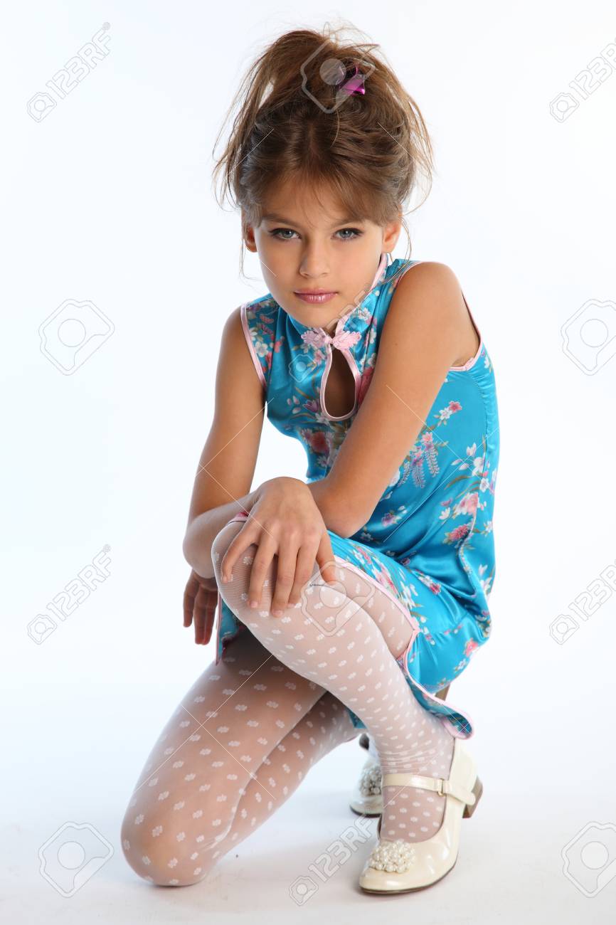 kids model in pantyhose Beautiful Girl In An Asian Blue Dress Is Sitting On A White Background.  Elegant Attractive Child With A Slender Body And Long Legs In White  Pantyhose. The Young Model 9 Years Old