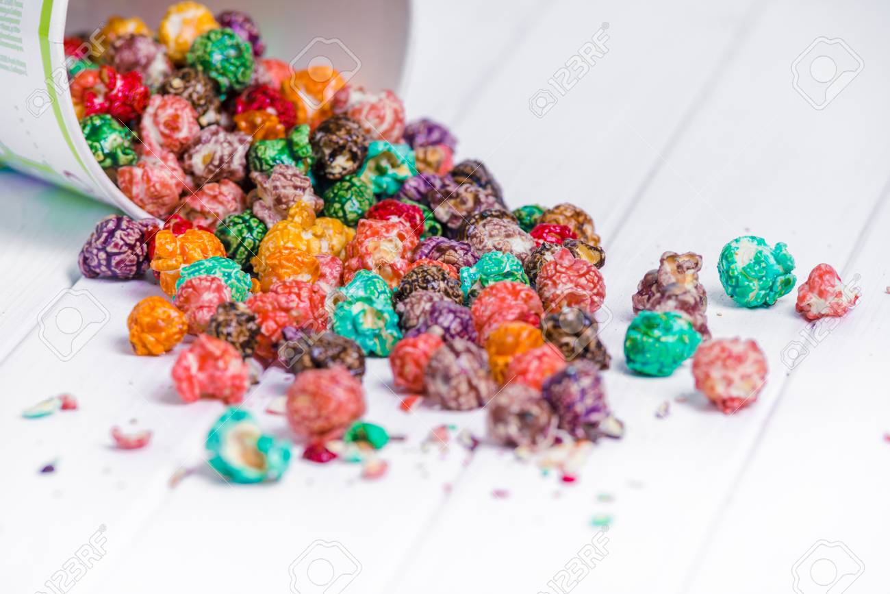 Brightly Colored Candied Popcorn, white background. Horizontal image of Junk food, fruit flavored popcorn in light pink bowl. Colorful, rainbow, candy coated popcorn. Shallow focus on popcorn in bowl - 97292624 Brightly Colored Candied Popcorn, white background. Horizontal image of Junk food, fruit flavored popcorn in light pink bowl. Colorful, rainbow, candy coated popcorn. Shallow focus on popcorn in bowl - 97292624