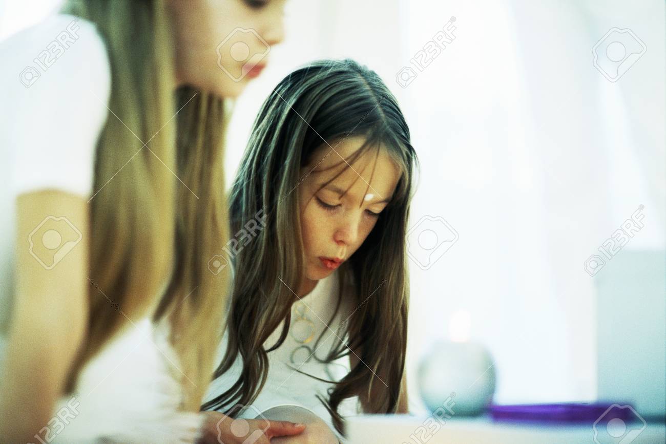 Stock Photo Two Girls Bending Over Candles Puckering Lips Cropped View Stock Photo Two Girls Bending Over Candles Puckering Lips Cropped View