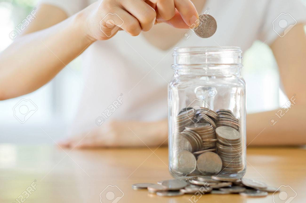 Woman hands with coins in glass jar, close up - 51186750 Woman hands with coins in glass jar, close up - 51186750