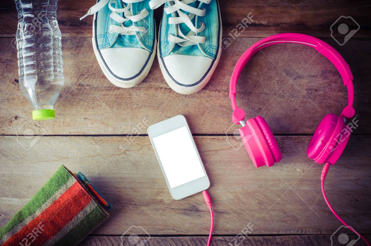 Shoes, water bottles headset smart phone scarf on a wooden table ready to depart. - 46154824 Shoes, water bottles headset smart phone scarf on a wooden table ready to depart. - 46154824