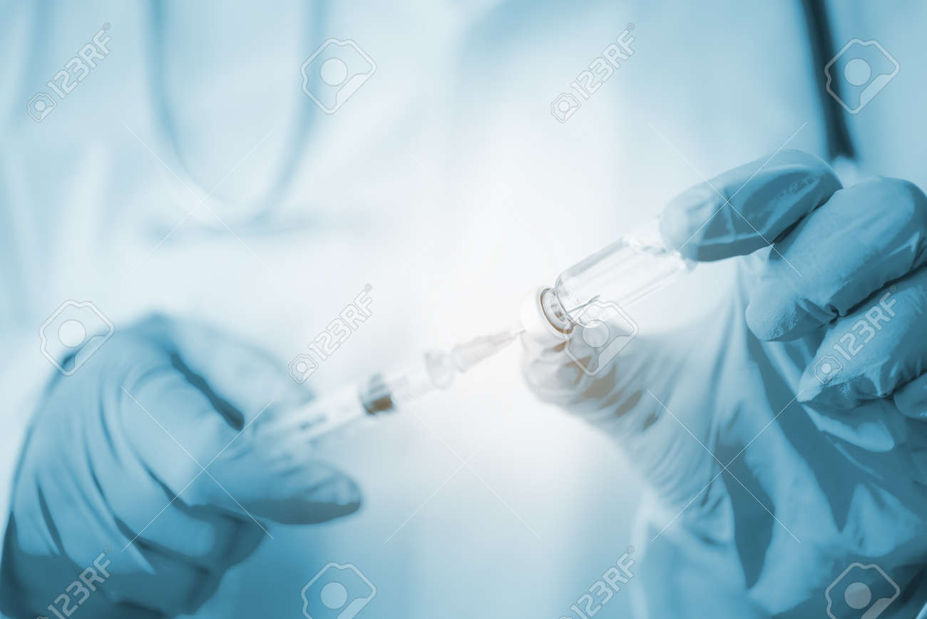 Doctor with syringe ready for injection of vaccine to patient. Vaccination concept. - 163301652 Doctor with syringe ready for injection of vaccine to patient. Vaccination concept. - 163301652