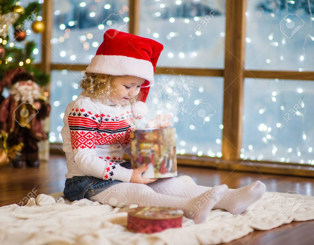 赤いサンタ帽子にクリスマスのギフトを開く女の子 の写真素材 画像素材 Image
