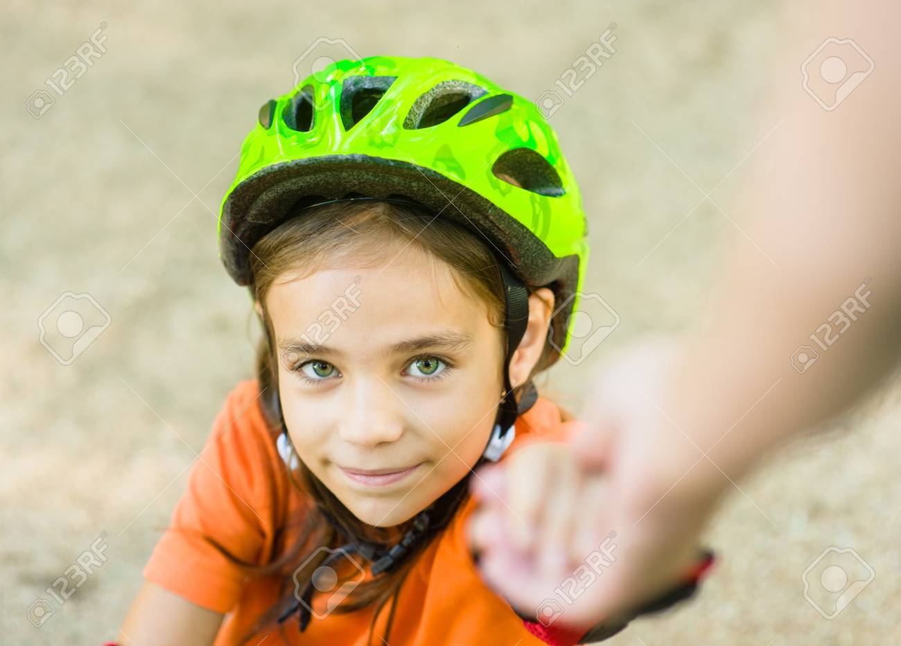 the parent helps the girl to climb after falling from the rollers parent helps