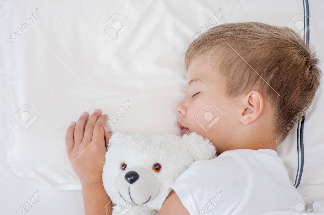 熊のぬいぐるみでベッドで寝ている少年 平面図です の写真素材 画像素材 Image