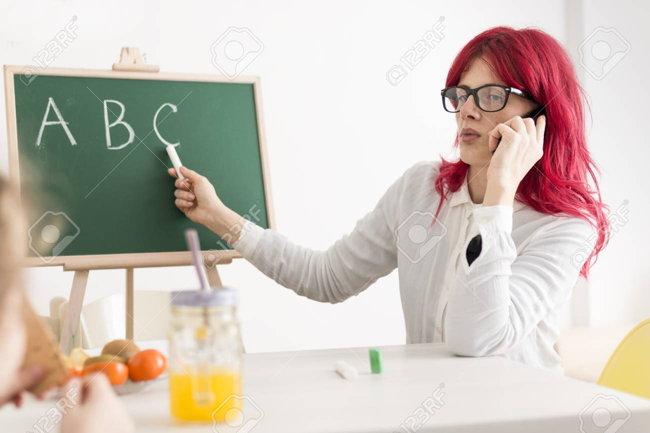 mom talking on the phone while teaching kid abc s with a chalkboard