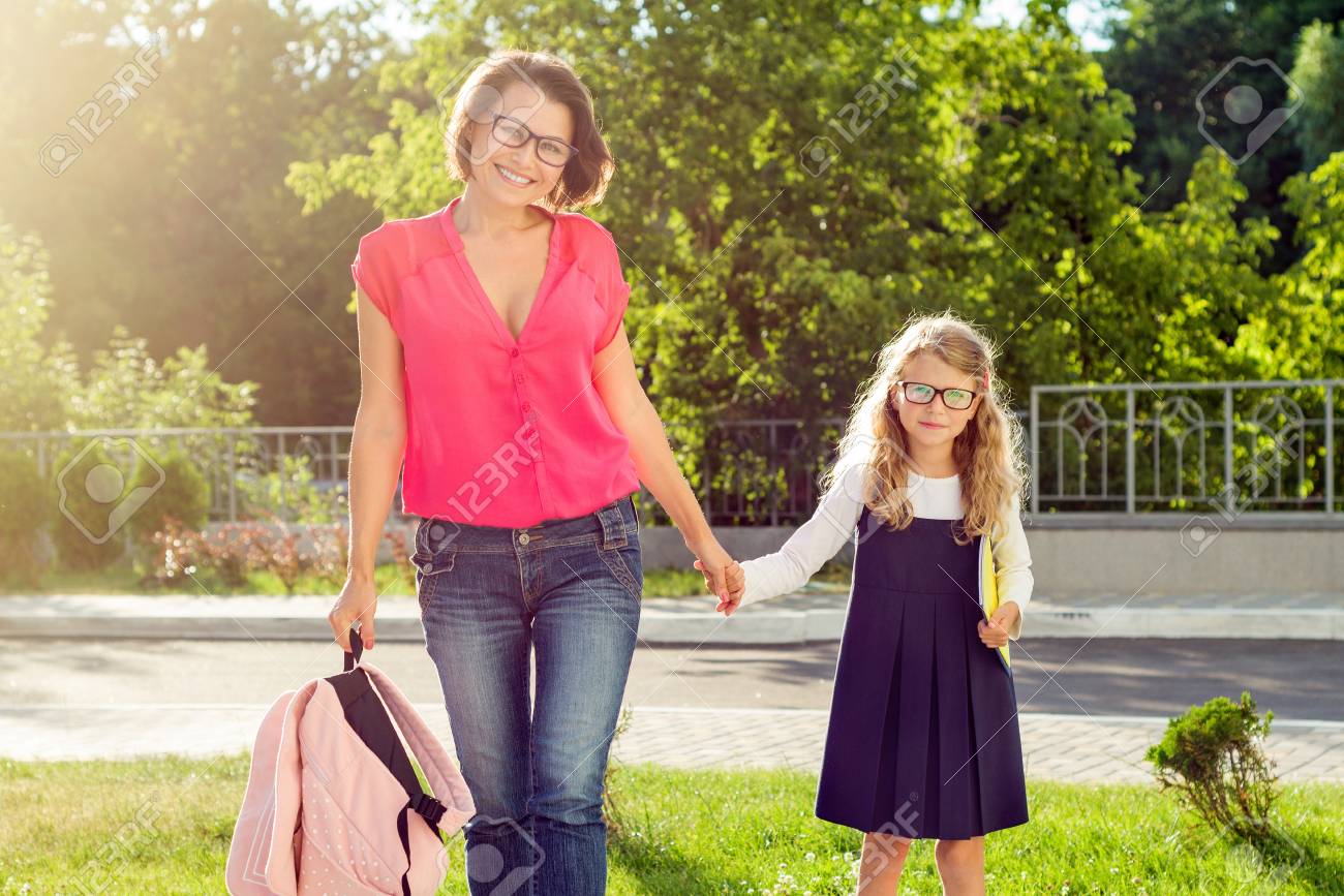 Mom And Pupil Of Elementary School Holding Hands The Parent Takes The Child To School Outdoors Return To The Concept Of The School Stock Photo Picture And Royalty Free Image Image