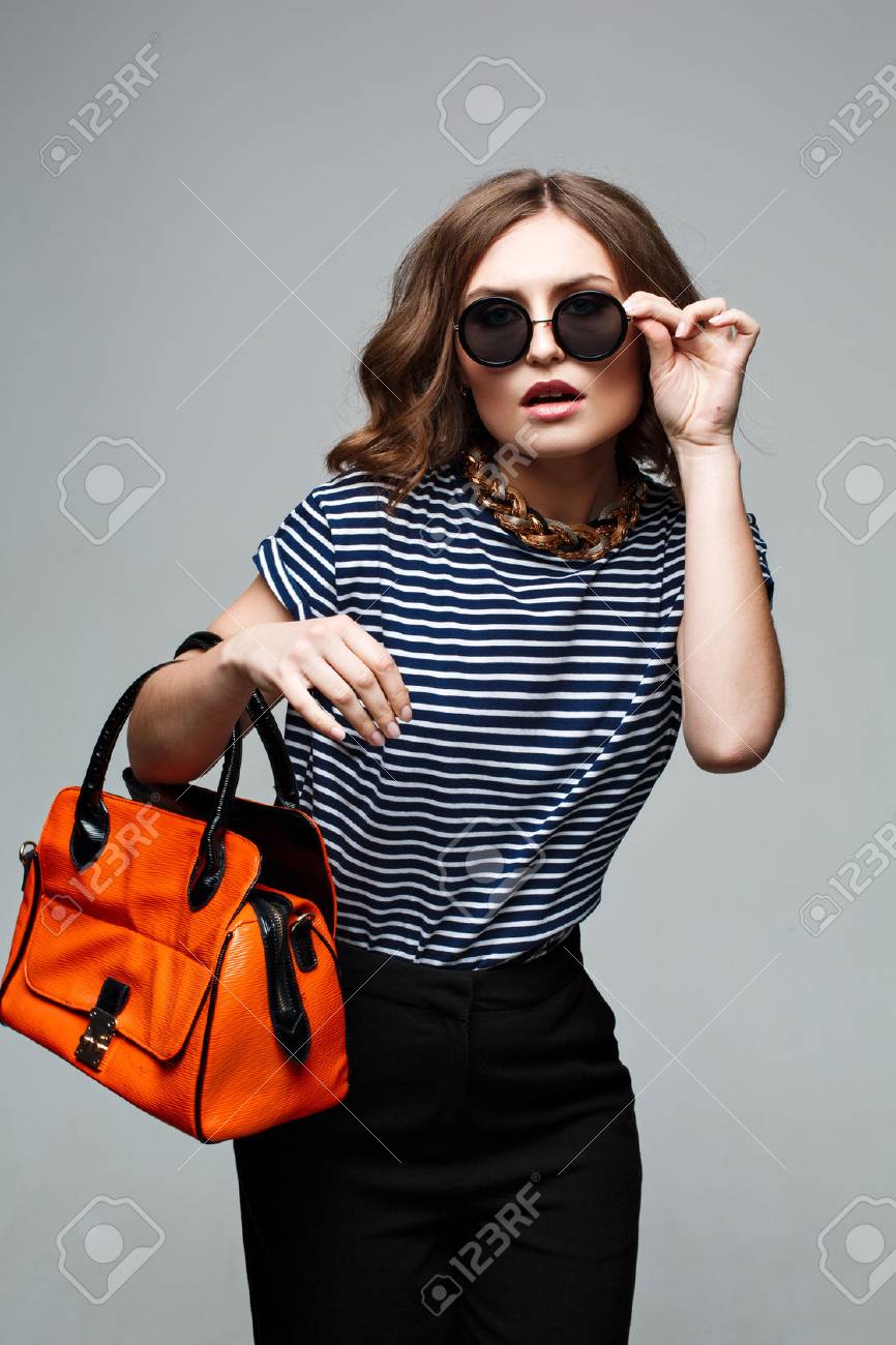 woman hands holding orange bag. Street look. Fashion look. Street..