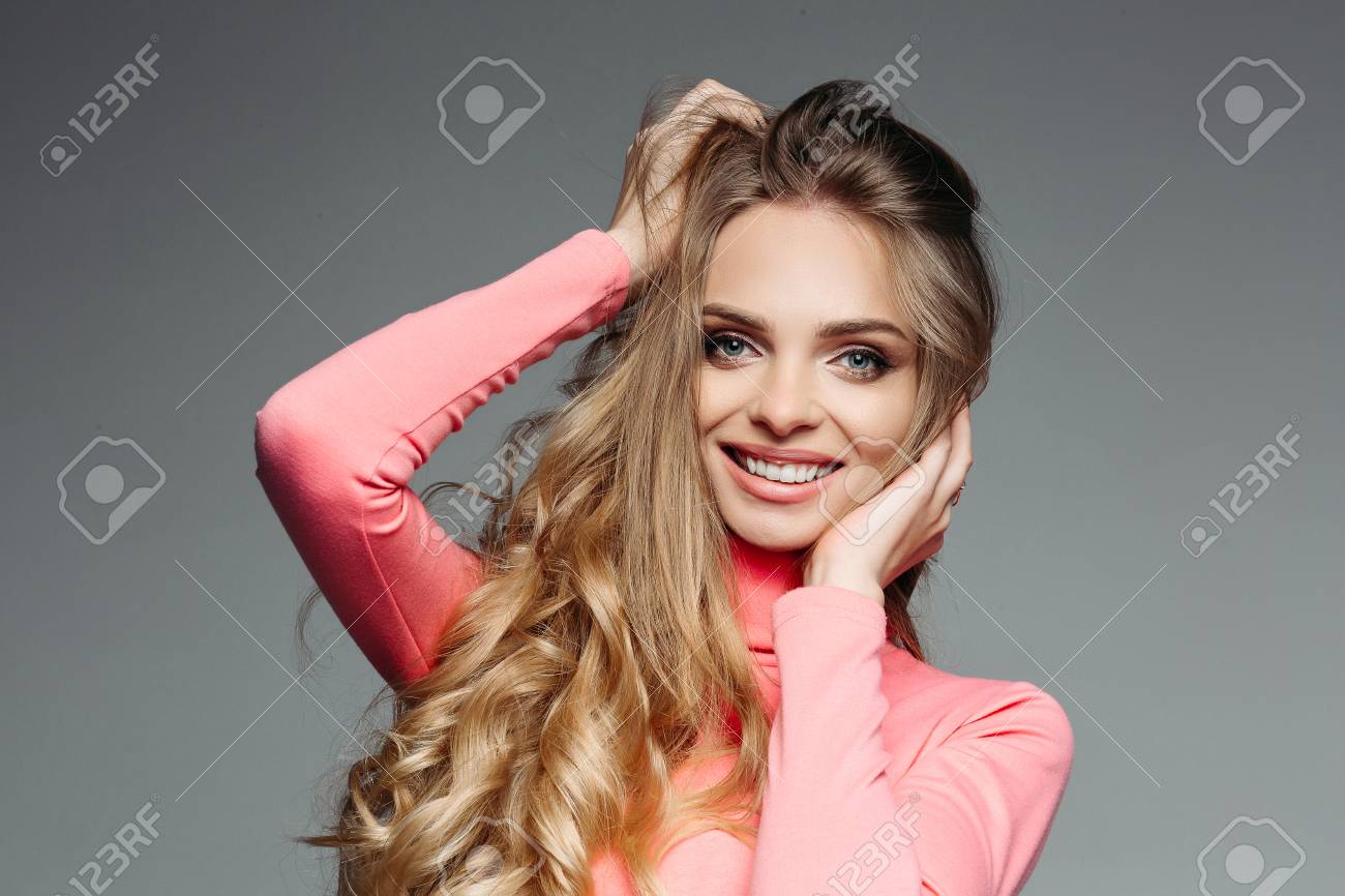 Studio Portrait Of A Cheerful Beautiful Girl With Long Blonde