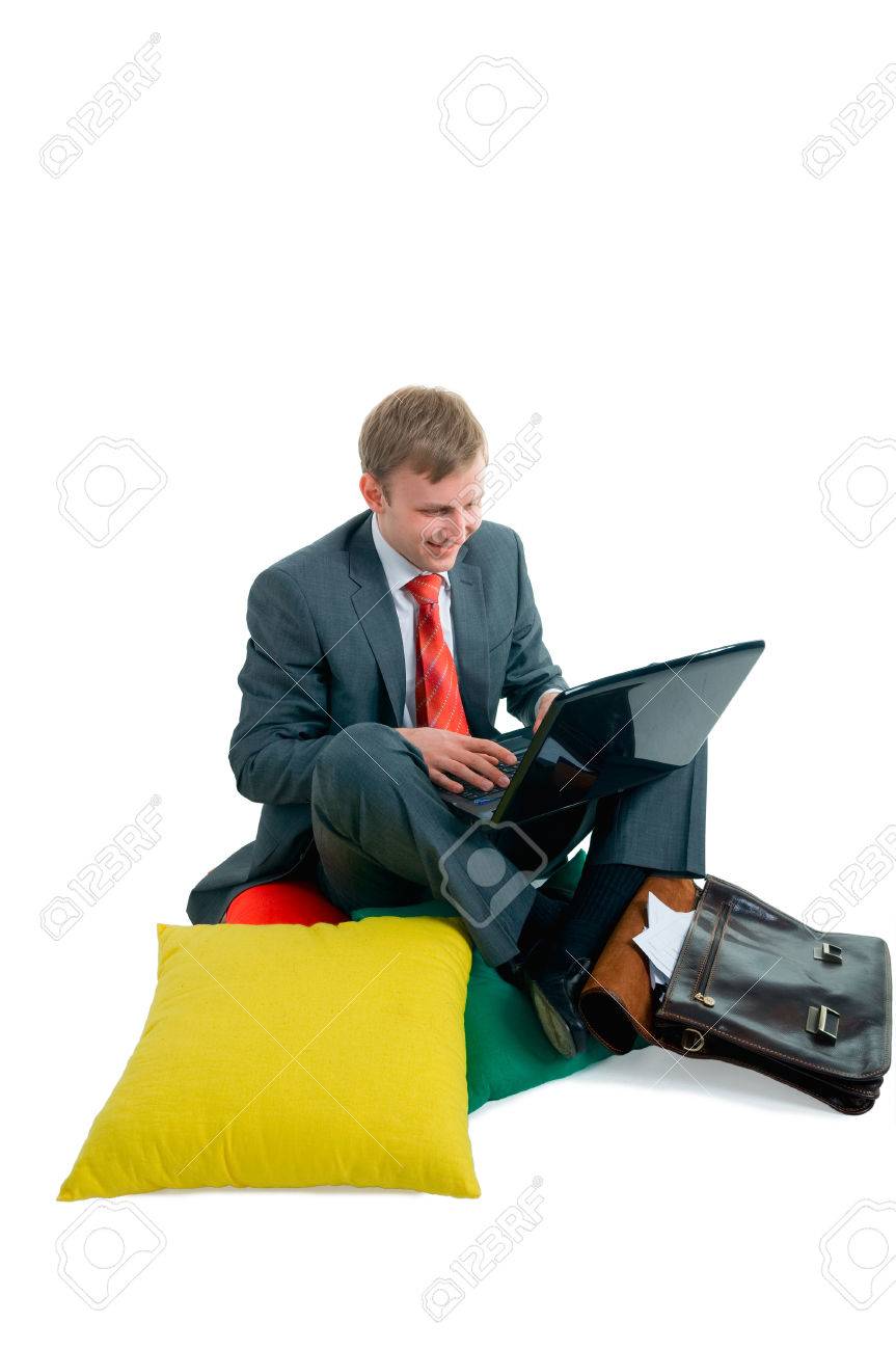 男性ビジネスマンが落ち着いている枕を動作中のコンピューターの背後にあります の写真素材 画像素材 Image