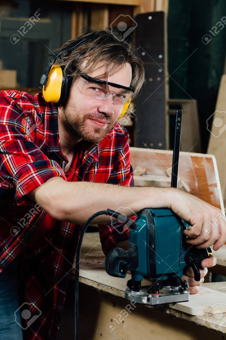 Carpenter working of manual hand milling machine in the carpentry workshop. joiner. Stock Photo