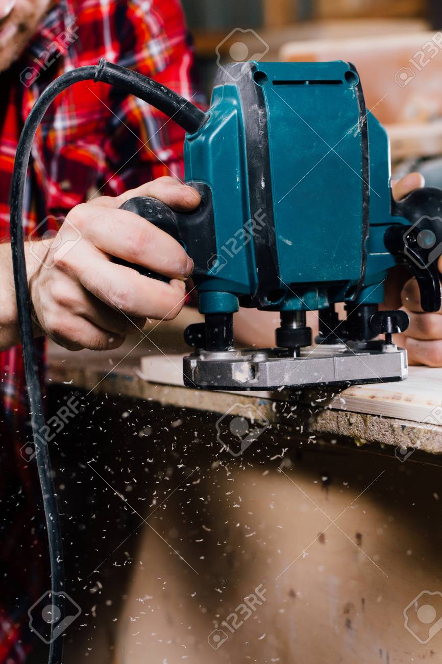 Carpenter working of manual hand milling machine in the carpentry workshop. joiner. Stock Photo