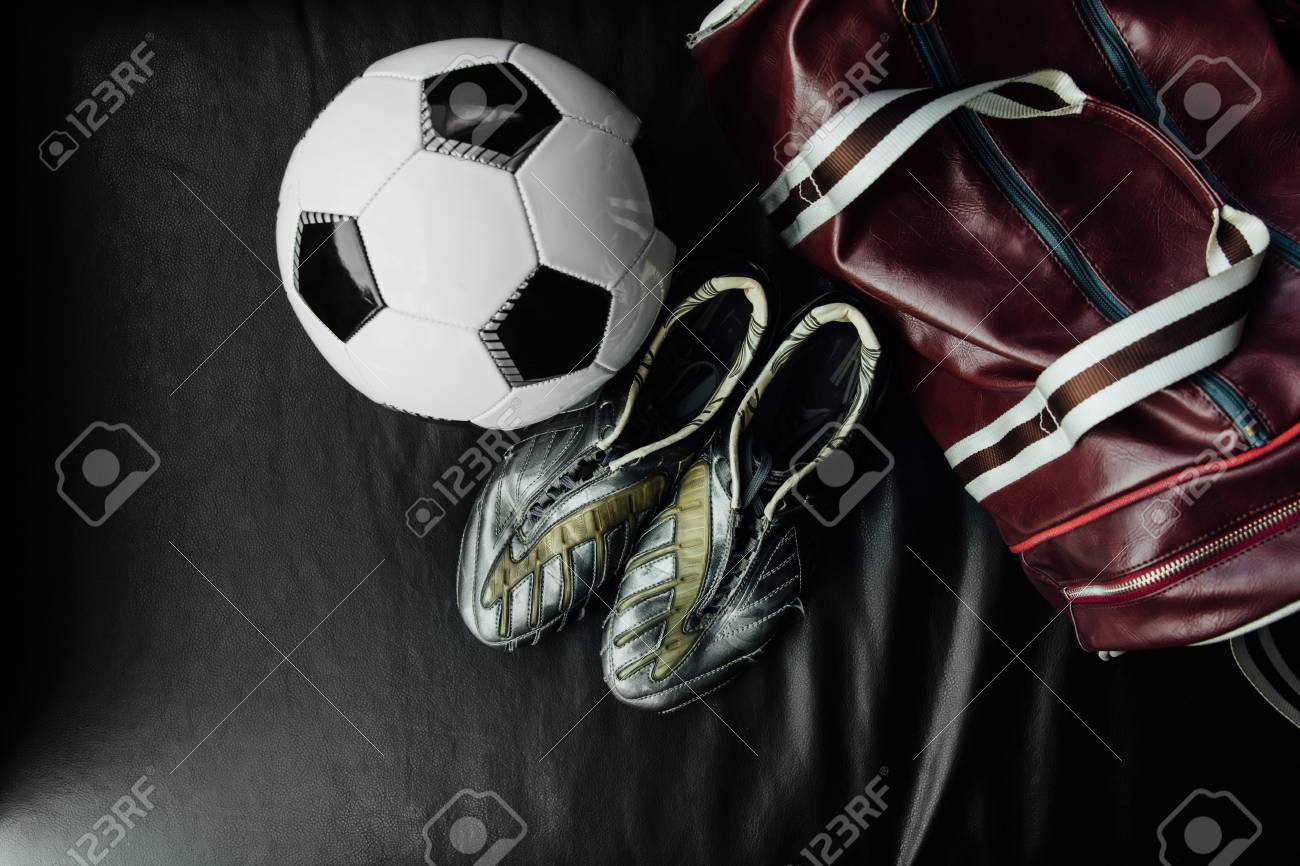 Flat lay soccer football accessories on a dark leather background Flat lay soccer football accessories on a dark leather background